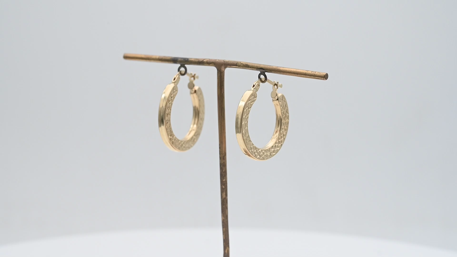 עגילי חישוק חלולים שטוחים עם ריקועים בצדדים, בקוטר 2.5 ס"מ ובעובי 2.9 מ"מ  - מק"ט 15125, זהב 14K